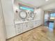 Elegant bathroom boasts double sinks, white cabinetry, decorative mirrors, and tile flooring at 1412 10Th St, Danville, IN 46122