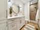 Modern bathroom featuring a round mirror, white vanity, and tiled shower with a decorative accent at 1412 10Th St, Danville, IN 46122