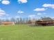 Expansive backyard showcasing a brick home with a deck and a large barn on a lush green lawn under a blue sky at 1412 10Th St, Danville, IN 46122