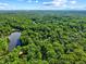Aerial shot of vast wooded property with lake and a scattering of houses providing seclusion and stunning natural beauty at 1413 N Lost Lake Rd, Columbus, IN 47201