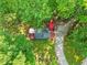 An aerial view shows the house surrounded by lush greenery and a stone driveway, with red and white umbrellas at 1413 N Lost Lake Rd, Columbus, IN 47201