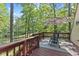 Relax on the wooden deck with shade umbrella and views of the wooded lot at 1413 N Lost Lake Rd, Columbus, IN 47201