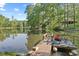 Waterfront property with dock, private lake, wooded area, and stunning lake views under a blue sky with sparse clouds at 1413 N Lost Lake Rd, Columbus, IN 47201