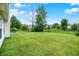 Expansive backyard with a large grassy area and mature trees, offering privacy and space at 15523 Follow Dr, Noblesville, IN 46060