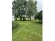 Lush backyard featuring mature trees and a wooden playset for outdoor fun at 1609 N Outer Dr, Lebanon, IN 46052