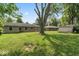 Expansive backyard featuring mature trees, well-kept lawn, and detached storage shed at 1613 Park Rd, Anderson, IN 46011