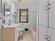 Bathroom with mint tile, vanity, pink bathtub, and storage cabinets at 1613 Park Rd, Anderson, IN 46011