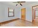 Bright bedroom featuring hardwood floors, a ceiling fan, and a window with natural light at 1613 Park Rd, Anderson, IN 46011