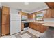 Functional kitchen featuring wooden cabinets, white appliances, and a convenient layout at 1613 Park Rd, Anderson, IN 46011