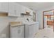 Bright laundry area features modern washer and dryer, neutral tones, and ample cabinet space for convenient storage at 1613 Park Rd, Anderson, IN 46011