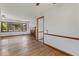 Well-lit living room with hardwood floors, fireplace, and windows, with views into the kitchen at 1613 Park Rd, Anderson, IN 46011