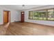 Bright living room features gleaming hardwood floors and a large window providing natural light at 1613 Park Rd, Anderson, IN 46011