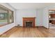 Inviting living room with hardwood floors and a traditional fireplace, complemented by a large window at 1613 Park Rd, Anderson, IN 46011