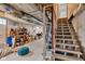 Unfinished basement with exposed ceiling, wooden staircase, and some storage items at 1618 Villa Ave, Indianapolis, IN 46203