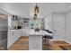 Bright kitchen features white cabinetry, stainless appliances, large island with seating and decorative backsplash at 1618 Villa Ave, Indianapolis, IN 46203