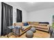 Comfortable living room with a sectional sofa, window with curtains, and hardwood floors at 1618 Villa Ave, Indianapolis, IN 46203