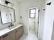 Well-lit bathroom featuring a single sink vanity, a modern mirror, and a separate toilet room at 1654 Fernley Dr, Westfield, IN 46074