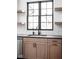 Well-lit kitchen features a black sink, cabinets, and black trimmed windows overlooking the neighborhood at 1655 Carrollton Rail Dr, Westfield, IN 46074