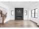 Modern living room featuring hardwood floors, fireplace, and black frame windows offering natural light at 1655 Carrollton Rail Dr, Westfield, IN 46074