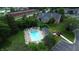 Aerial view of a condo building and a community pool with lounge chairs surrounded by landscaping at 207 Keats Ct # 102, Carmel, IN 46032