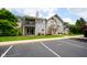 Exterior view of the building with a balcony, parking lot, and well-manicured lawn at 207 Keats Ct # 102, Carmel, IN 46032