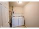 Bright laundry room with washer, dryer, and storage shelving for optimal functionality at 207 Keats Ct # 102, Carmel, IN 46032