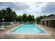 Community pool area surrounded by mature trees and lounge chairs at 207 Keats Ct # 102, Carmel, IN 46032
