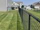 Backyard view showcases a chain-link fence, a well-manicured lawn, and neighboring houses at 2253 Jaybird Dr, Greenfield, IN 46140