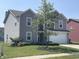 Two-story house with well-maintained lawn, landscaping, and a tree in the front yard at 2253 Jaybird Dr, Greenfield, IN 46140
