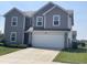 Charming two-story home featuring gray siding, manicured lawn, and a two-car garage at 2253 Jaybird Dr, Greenfield, IN 46140