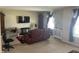 A living room features a recliner, TV, large windows with curtains and carpeted floors at 2253 Jaybird Dr, Greenfield, IN 46140