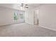 Sunlit main bedroom with plush carpeting, white walls, ceiling fan, and ensuite bath featuring a window view at 2270 Collins Way, Greenfield, IN 46140