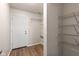 Neutral mud room with wood-look vinyl flooring, white door, and wire shelving for easy storage and organization at 2270 Collins Way, Greenfield, IN 46140