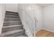 Carpeted staircase with white railing and banister ascending to the next level, adjacent to two white paneled doors at 2270 Collins Way, Greenfield, IN 46140