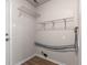 Compact utility room featuring wire shelving, blue pipes, wood look flooring, and connections for laundry appliances at 2270 Collins Way, Greenfield, IN 46140