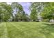 Wide shot of the home's backyard featuring a manicured lawn and mature trees at 2553 Forest Hills Blvd, Greenwood, IN 46143