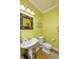 Bright powder room featuring a pedestal sink, toilet, and a decorative mirror over hardwood floors at 2553 Forest Hills Blvd, Greenwood, IN 46143