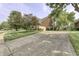 Long driveway leads to a well-maintained brick home featuring mature landscaping and attached garage at 2553 Forest Hills Blvd, Greenwood, IN 46143