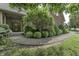 A sidewalk leads to the front entrance of a beautiful brick home with mature trees and landscaping at 2553 Forest Hills Blvd, Greenwood, IN 46143
