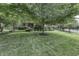 A lush green lawn and mature trees frame the charming exterior of this brick home at 2553 Forest Hills Blvd, Greenwood, IN 46143