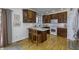 Well-lit kitchen with hardwood floors, wooden cabinets, white appliances, and a cozy breakfast bar with seating at 2553 Forest Hills Blvd, Greenwood, IN 46143