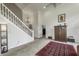 View of a well-lit living area with stairs and dark wood furniture; an eye-catching rug adorns the light carpeted floor at 2553 Forest Hills Blvd, Greenwood, IN 46143