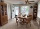 Dining area with an elegant table set with four chairs, a ceiling fan, and a window at 260 S 250 W, Greenfield, IN 46140