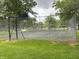A fenced tennis court with basketball hoop provides recreational opportunities for residents at 260 S 250 W, Greenfield, IN 46140