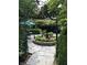 Picturesque backyard featuring a stone patio, fountain, and manicured hedges at 3317 S 100 E, Greenfield, IN 46140