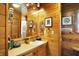 Rustic bathroom featuring wood paneling, vanity with sink, and a large mirror reflecting the cozy space at 3317 S 100 E, Greenfield, IN 46140