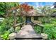 Charming front entrance features a wooden bridge walkway surrounded by lush landscaping at 3317 S 100 E, Greenfield, IN 46140