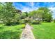 Spacious front yard with a stone pathway leading to a charming home, surrounded by lush landscaping and mature trees at 3317 S 100 E, Greenfield, IN 46140