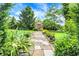 Idyllic greenhouse with a stone path, surrounded by lush greenery and vibrant flowers, a gardener's dream at 3317 S 100 E, Greenfield, IN 46140