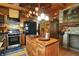 Spacious kitchen features a stone accent wall, wood cabinets, and an island for food preparation and seating at 3317 S 100 E, Greenfield, IN 46140